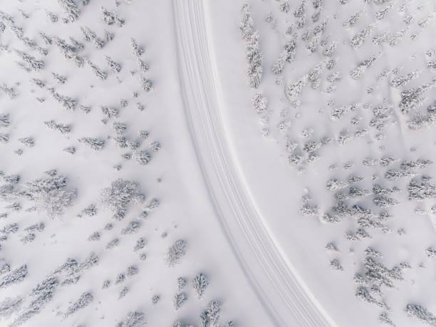 вид с воздуха на дорогу в зимнем снежном лесу в финляндии - aerial view landscape scenics snow стоковые фото и изображения