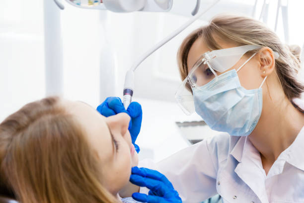 istock Young Woman Dentist working with a Patient 902492244