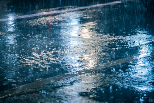 colored lights reflected in the wet asphalt in the rain
