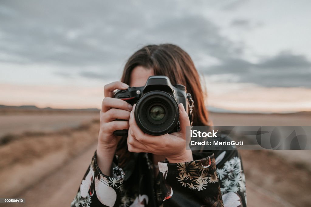 Joven mujer tomando una foto - Foto de stock de Fotógrafo libre de derechos