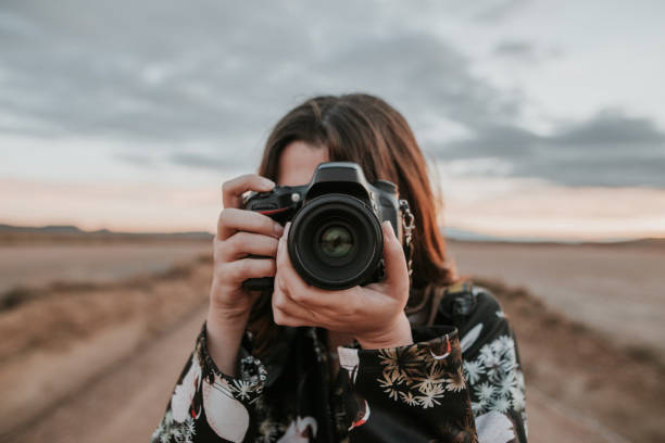 joven mujer tomando una foto - cámara réflex digital de objetivo único fotos fotografías e imágenes de stock