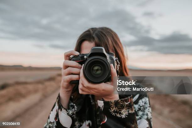 Joven Mujer Tomando Una Foto Foto de stock y más banco de imágenes de Fotógrafo - Fotógrafo, Cámara, Sacar una foto