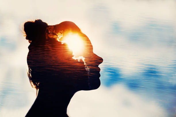 Power of mind concept. The Light Head. Silhouette of young woman on sky background with sun in her head. obedience photos stock pictures, royalty-free photos & images