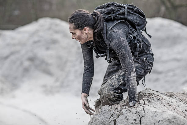 istock Beautiful brunette female military member training hard on a sand hill run 902520910