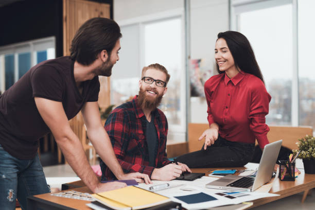 istock The designer and his clients are having fun discussing something in the office. 902528866