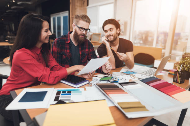 istock The designer and his clients are considering design projects on paper. 902529394