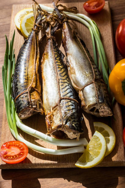 istock Smoked mackerel fish on wooden hardboard on wooden table 902531914