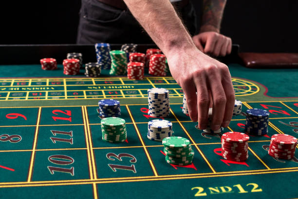 una primer plano imagen vibrante de mesa verde casino con ruleta, con las manos de fichas crupier y multicoloras - roulette table fotografías e imágenes de stock