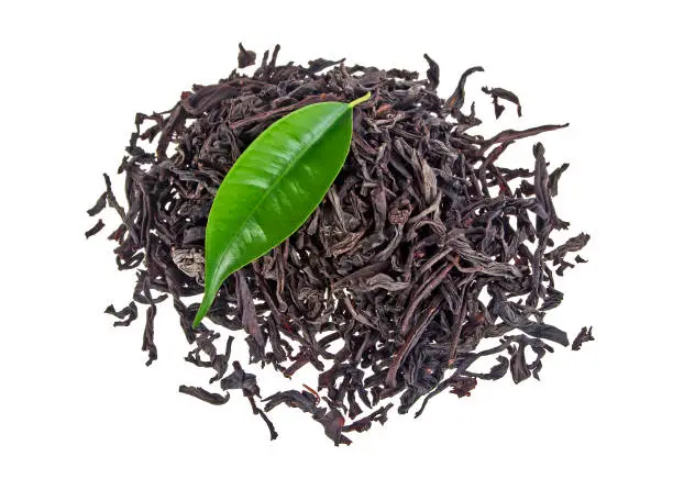 Black tea with leaf isolated on a white background, top view