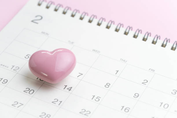 Calendar with pink heart shape on 14 February on pink background using as romantic Valentines day concept.