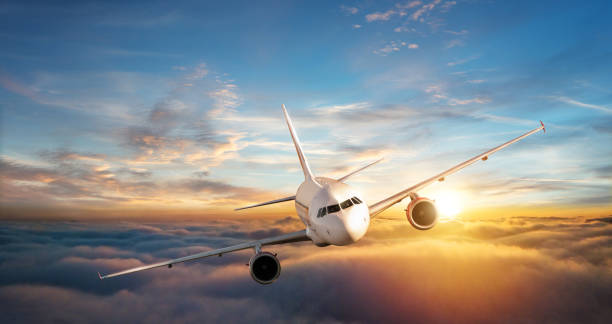 istock Commercial airplane jetliner flying above clouds in beautiful sunset light. 902554140
