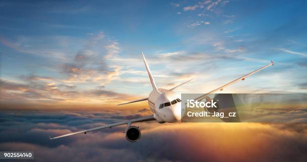 Commercial Airplane Jetliner Flying Above Clouds In Beautiful Sunset Light Stock Photo - Download Image Now