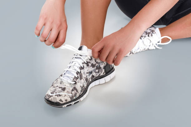 istock Sportswoman tying her shoelaces before the training. Close up 902557396