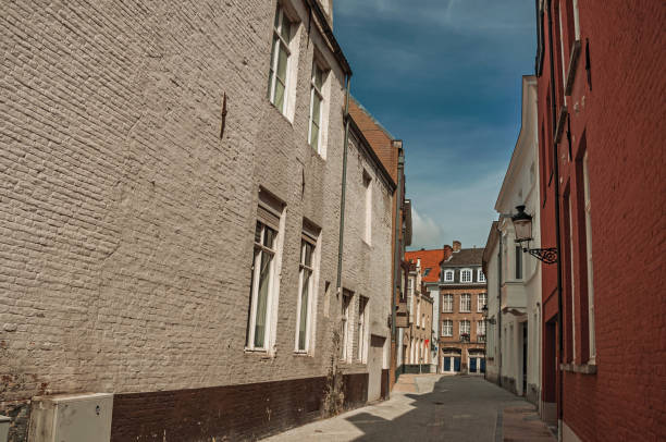 istock Quite empty street with brick buildings and blue sky at Bruges. 902559876
