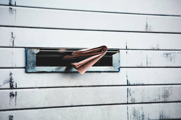 Daily newspaper sticking through a letterbox