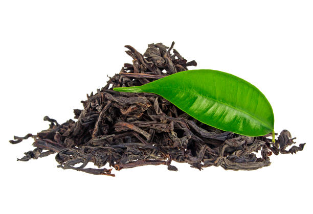 istock Heap of dry black tea with green tea leaf isolated on a white background 902567954