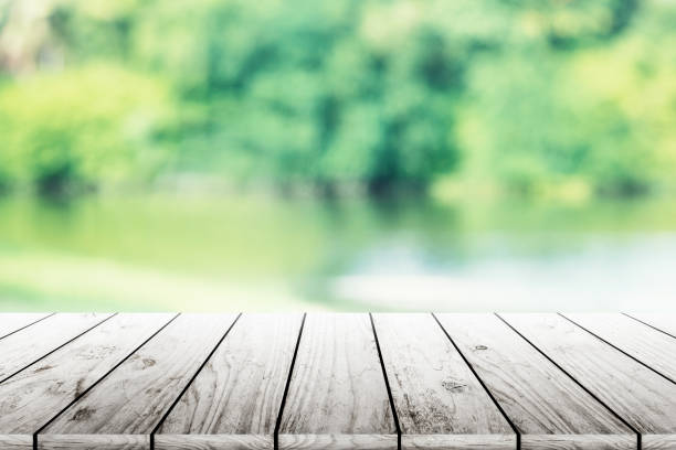 istock Empty wooden table with party in garden background blurred. 902579330