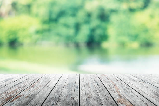 istock Empty wooden table with party in garden background blurred. 902579724
