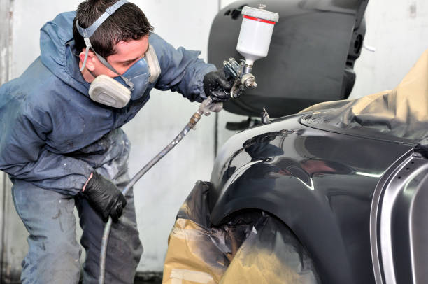 istock Professional car painter working at a black vehicle. 902579778