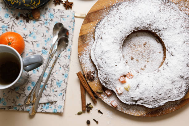 istock Freshly baked cupcake, sprinkled with sugar powder, is lying on a kitchen table. 902582472