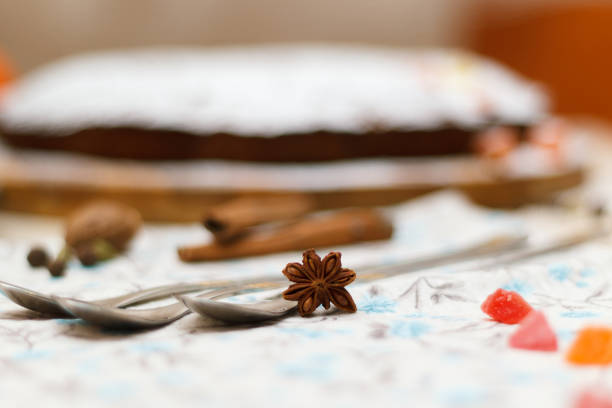 Freshly baked cupcake, sprinkled with sugar powder, is lying on a kitchen table.