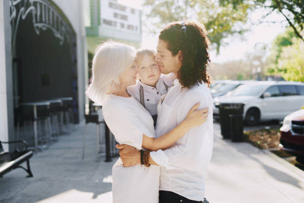 beautiful young family dad mom and a little boy with blond hair walking around the city and enjoying the sunshine, multi family black and white three way kiss stock pictures, royalty-free photos & images
