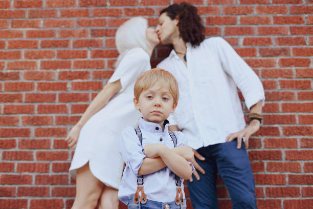 beautiful young family dad mom and a little boy with blond hair walking around the city and enjoying the sunshine, multi family black and white three way kiss stock pictures, royalty-free photos & images