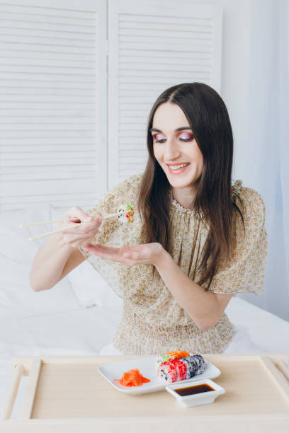 istock Young brunette woman eating sushi 902598768