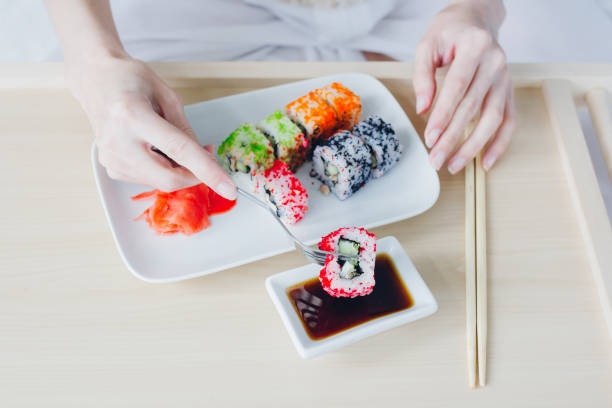 istock Woman eating sushi with a fork 902599184