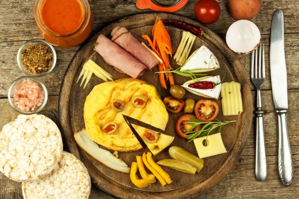 istock Small egg omelet on the kitchen board. Vegetables and spices. 902602336
