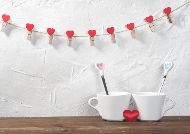 istock Valentine's day holiday celebration with hearts and cups over bokeh background 902605348