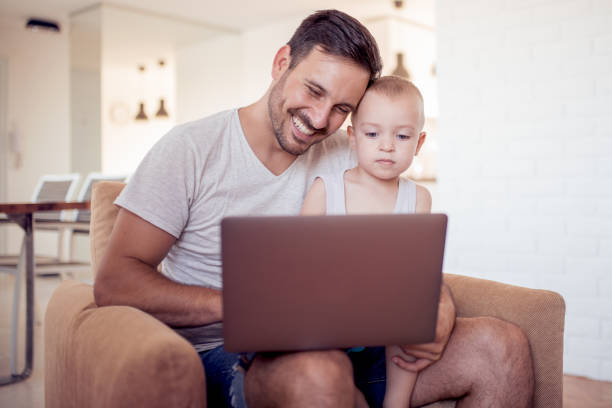 istock Happy father and little son with tablet pc computer sitting on 902609850