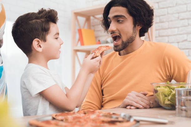 istock A little boy and his arab father eat pizza together. 902610258