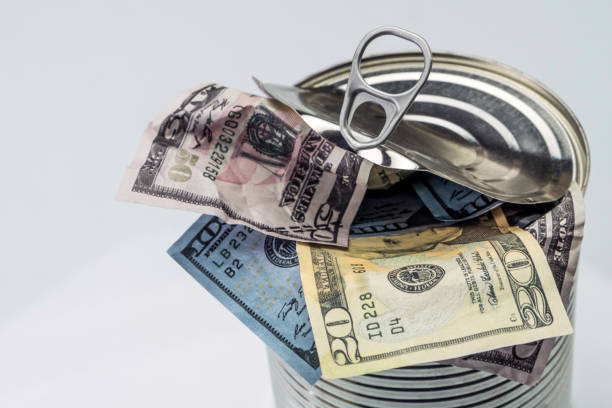 istock Canned cans full of dollar bills, conceptual image isolated on white background 902610262