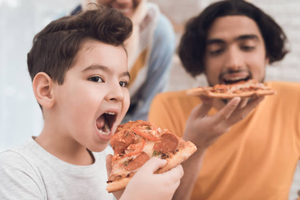 istock A little boy and his arab father eat pizza together. 902610320