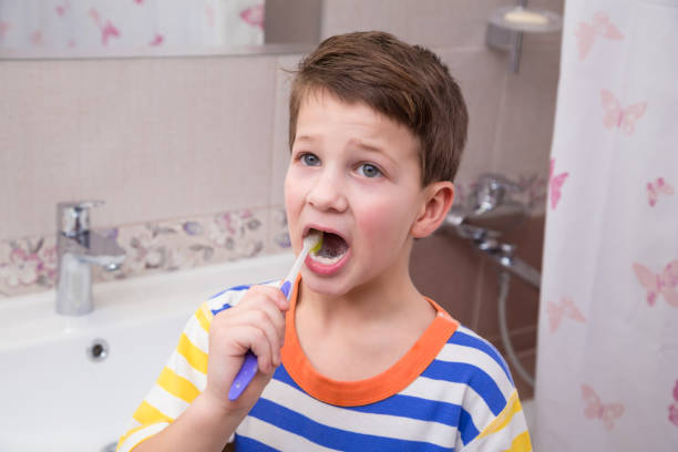 istock Sad little boy cleaning his teeth in the bathroom 902613302