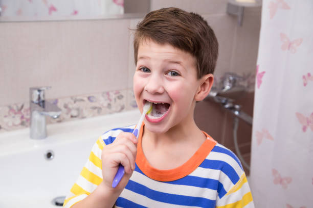 istock Little boy cleaning his teeth in the bathroom 902613330