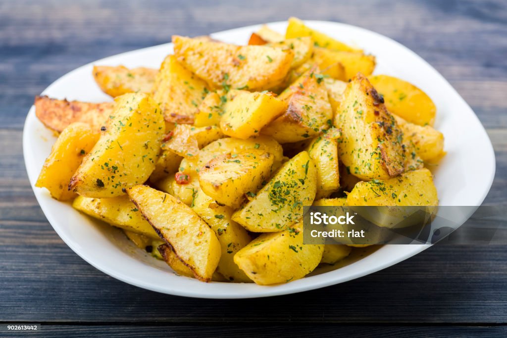 Plate with roasted potatoes Plate with roasted potatoes cut into quarters Baked Stock Photo