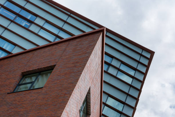 istock Sharp brick office building in front of square glass one 902620822