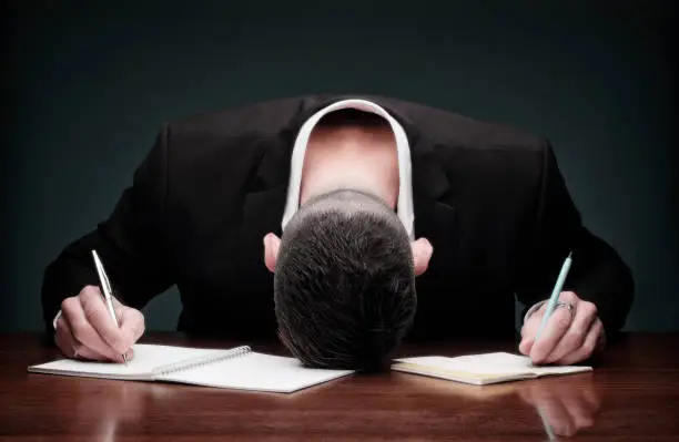 Maybe too tired? This businessman tried to do too much work and collapses on his desk