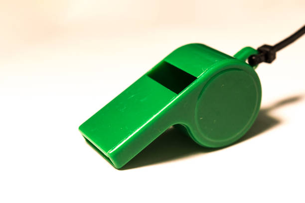 istock A green plastic whistle of a referee and a white background 902628112