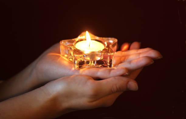 istock hands of a woman with a lit tea light in star shape 902628410