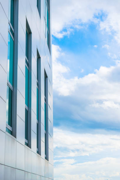 istock Continuous facade of a modern building with background of blue sky and clouds 902631634