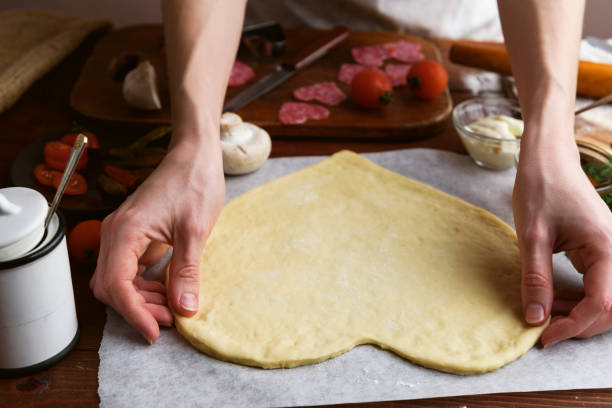 o chef faz um coração de pizza para o feriado do dia dos namorados. clássico italiano pizza com salame e mussarela - cheese making - fotografias e filmes do acervo