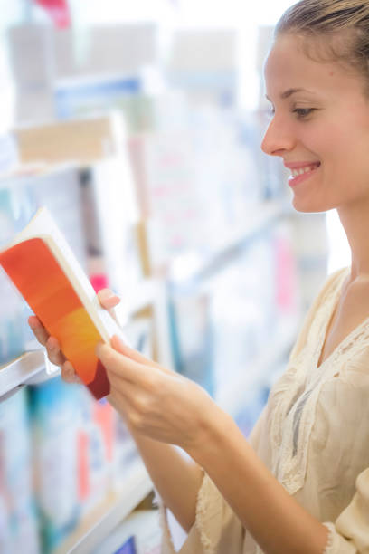 istock Beautiful woman reading book in bookstore 902635674