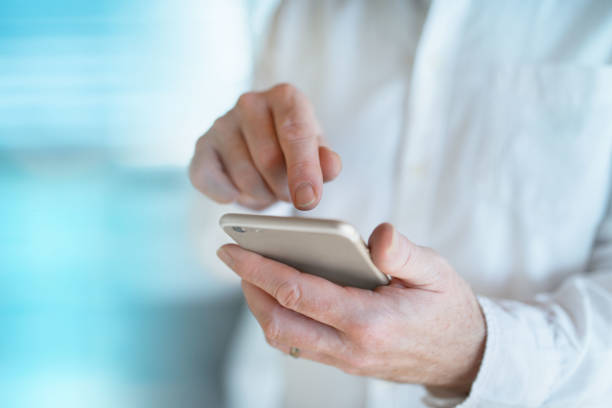 istock Doctor types information into his mobile phone 902635758