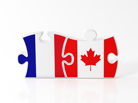 Jigsaw puzzle pieces textured with French and Canadian flags on white. Horizontal composition with copy space. Clipping path is included.