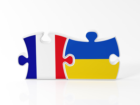 Jigsaw puzzle pieces textured with French and Ukrainian flags on white. Horizontal composition with copy space. Clipping path is included.