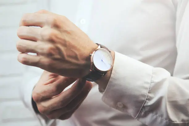 Businessman checking time on his wristwatch men  hand with a watch