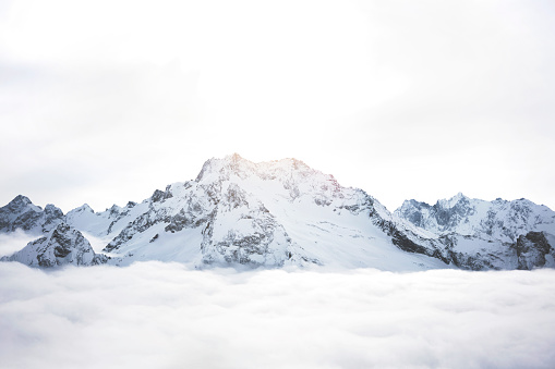 Montañas nevadas por encima de las nubes. Macizo del gran invierno de rocas photo